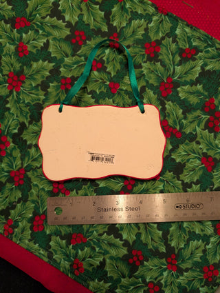 Christmas Kisses & Holiday Hugs ceramic ornament with red border and green ribbon