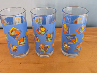 Small tumblers with framed multicolor abstract tulips in a blue background, set of 3