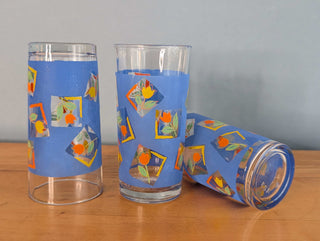 Small tumblers with framed multicolor abstract tulips in a blue background, set of 3