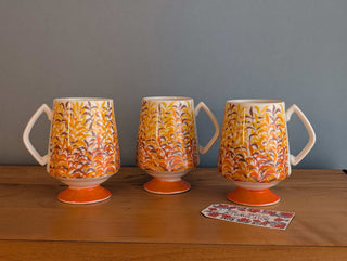 Trio of artisanal ceramic mugs, footed, autumn colors, leafy silhouette decals