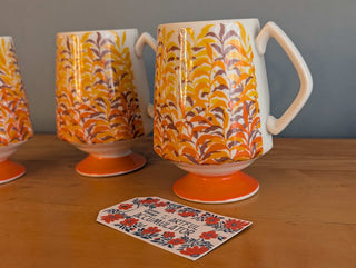 Trio of artisanal ceramic mugs, footed, autumn colors, leafy silhouette decals