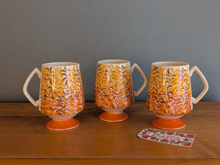 Trio of artisanal ceramic mugs, footed, autumn colors, leafy silhouette decals