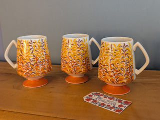 Trio of artisanal ceramic mugs, footed, autumn colors, leafy silhouette decals