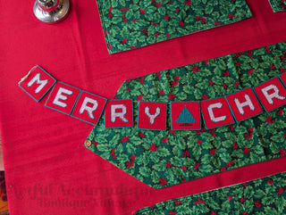 "Merry Christmas" Plastic Canvas Banner with green, red, and white stitched yarn