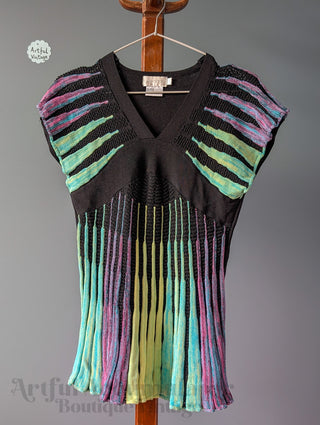 Colorful fringe vest on a hanger against a gray background