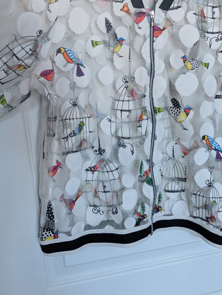 white tulle mesh with circles, zip up see through cardigan with colorful flying birds and bird cages