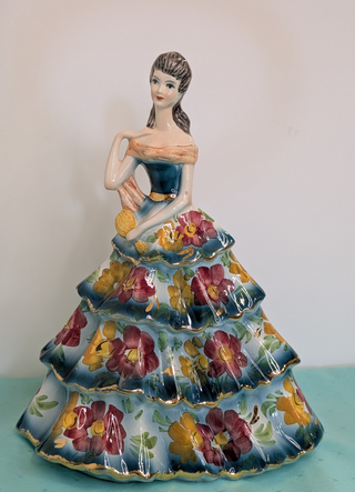 GIOVANNI GIRARDI 1950's figure of a beautiful woman wearing a tiered floral gown in blue, pink, and gold, a light orange sash, and a hand mirror